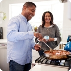 Couple cook dinner together.